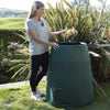 Image of Person disposing of food waste into a Green Johanna compost bin in a garden setting