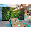 Image of Dining area with a wooden table, green chairs, and a living plant wall.