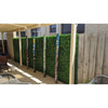 Image of Artificial Mixed Boxwood 1m x 1m Plant Panel UV Stabilised mounted along a patio fence set against brick and timber with decorative painted poles in front