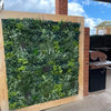 Image of Artificial Vertical Garden of Eden Installed on a patio area with a timber frame surrounding it and a barbeque visible in the background