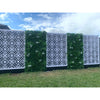 Image of Artificial White Tropics Vertical Garden Wall Panel installed on either side of a patterned white geometric screen