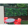 Image of m x 1m UV Stabilised Coastal Greenery Artificial Vertical Garden Panel installed wooden fence in an outdoor setting with tables and chairs