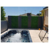 Image of A sunny modern backyard with a hot tub, patterned privacy fence of Artificial Deluxe Buxus Hedge Wall Panels and dark slats, light-tiled patio, and sports accessories