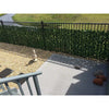 Image of Double Sided Artificial Ivy Roll 3m x 1m Screen installed on an outdoor railing beside a stone-paved walkway near the staircase