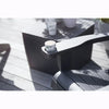 Image of Black chair with a cup holder on a wooden deck