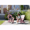 Image of Two people sitting on pink Adirondack chairs in a garden setting.