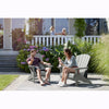 Image of Two people sitting on Adirondack chairs in a garden setting.