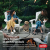 Image of Two women sitting in Keter Adirondack chairs with a dog by a fire pit, surrounded by nature.