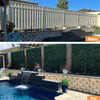 Image of A backyard is transformed from a plain metal fenced space into a luxurious pool oasis, featuring a cascading water feature, potted plants and tall Artificial Photinia Hedge Plant Wall Screening Panels