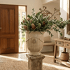 Image of sand glazed french urn in entryway on a pillar with a floral arrangement