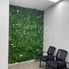 Image of Artificial White Tropics Vertical Garden Wall Panel installed in a waiting room with two chairs in the foreground