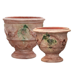 Two terracotta pots with decorative designs on a white background