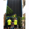 Image of Three workers in high-visibility vests installing a large vertical garden system.