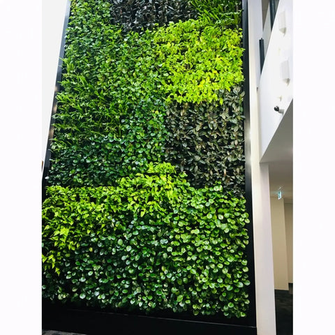 Green foliage wall on a white wall