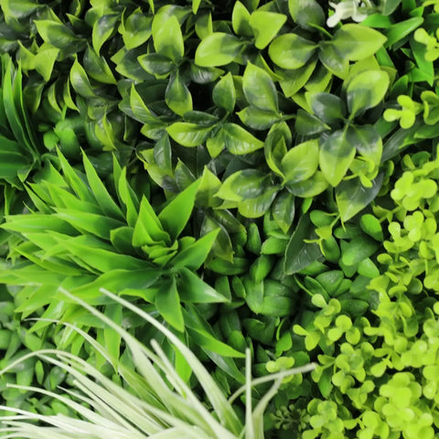Artificial forest floor greenery panel with various types of green plants close up