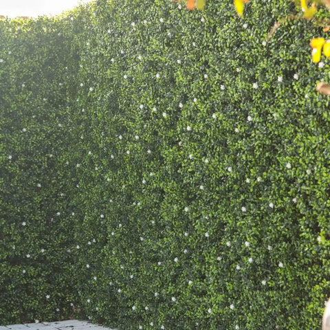 A close up angled shot of the Artificial Flowering Buxus Hedge Plant Panel as a decorative or privacy wall