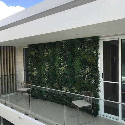 Artificial Green Forest Vertical Garden Panel Installed on a Balcony with two seats and glass railing