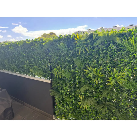 Green Tropics Artificial Plant Wall Panel installed along the railing of a balcony or an outdoor terrace