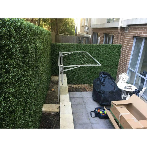 Artificial Premium Natural Buxus Panel installed in the backyard at the laundry area with chairs, table and tools