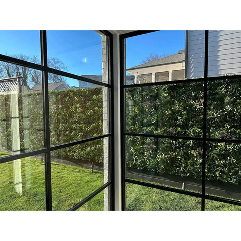 View out a window towards the Artificial Vertical Garden of Eden Installed in the Garden on a fence