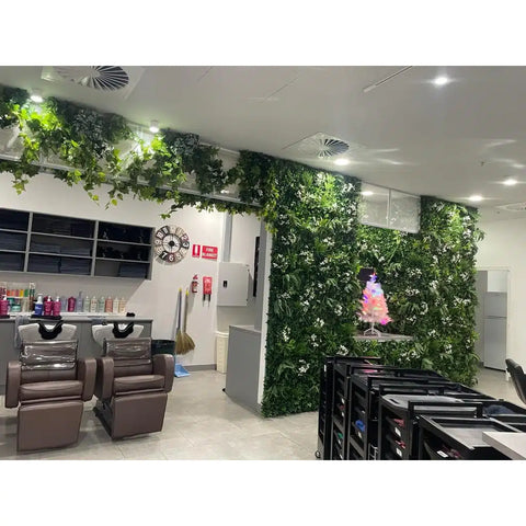 Artificial White Tropics Vertical Garden Wall Panels installed inside a modern salon with reclining wash chairs positioned near shelves stocked with colorful haircare products