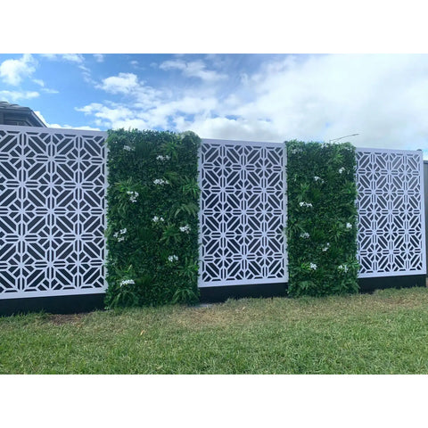 Artificial White Tropics Vertical Garden Wall Panel installed on either side of a patterned white geometric screen