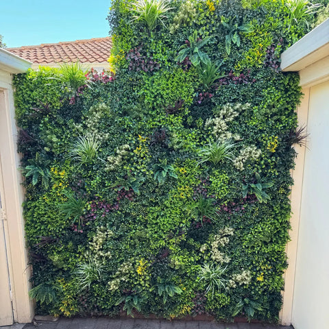Evergreen Rainforest Recycled Artificial Green Wall Panel installed in a frame outdoors beside the backdoor at a residential property