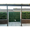 Image of The center features Artificial Ivy Leaf Hedge Panels while the flanking panels showcase varied vertical gardens with mixed artificial plant textures and species set above low decorative stacked stone planter boxes in front of the paved outdoor living space