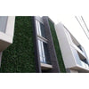 Image of A modern multi-story building with a geometric design, large glass windows, and installed Artificial Photinia Hedge Plant Wall Screening Panel adding contrast to the facade
