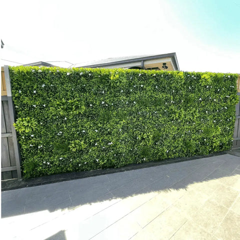 Artificial White Oasis Vertical Garden Panel mounted on a large colourbond fence along a tiled residential walkway
