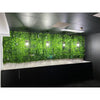 Image of Artificial White Oasis Vertical Garden Panel installed to a wall accented by four warm lantern style lights. Below is a black cabinet with a white countertop all framed by a modern ceiling with lighting and ventilation