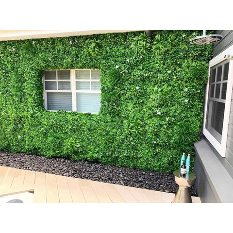 Artificial White Oasis Vertical Garden Panel installed on a wall  around the window of a residential area with the black stone pebbled walkway below