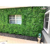 Image of Artificial White Oasis Vertical Garden Panel installed on a wall  around the window of a residential area with the black stone pebbled walkway below